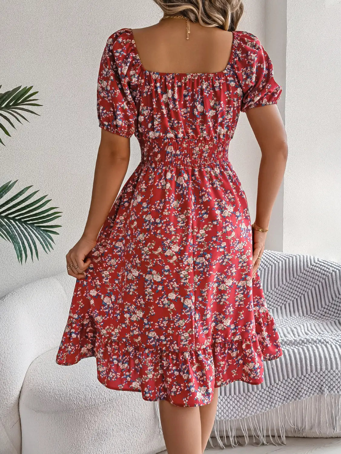Robe d’été à imprimé floral rouge, avec manches courtes bouffantes, encolure carrée et détails à volants.