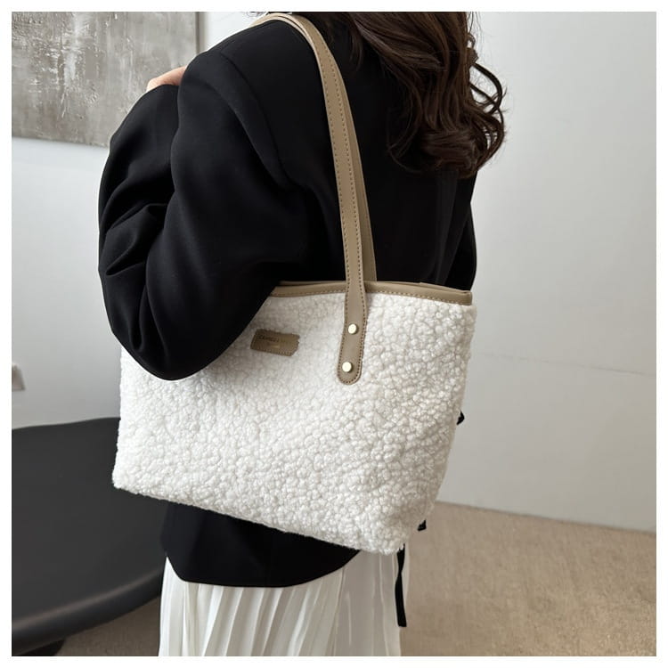 Brown faux fur tote bag featuring white fluffy shearling material with beige leather straps and gold tone hardware.