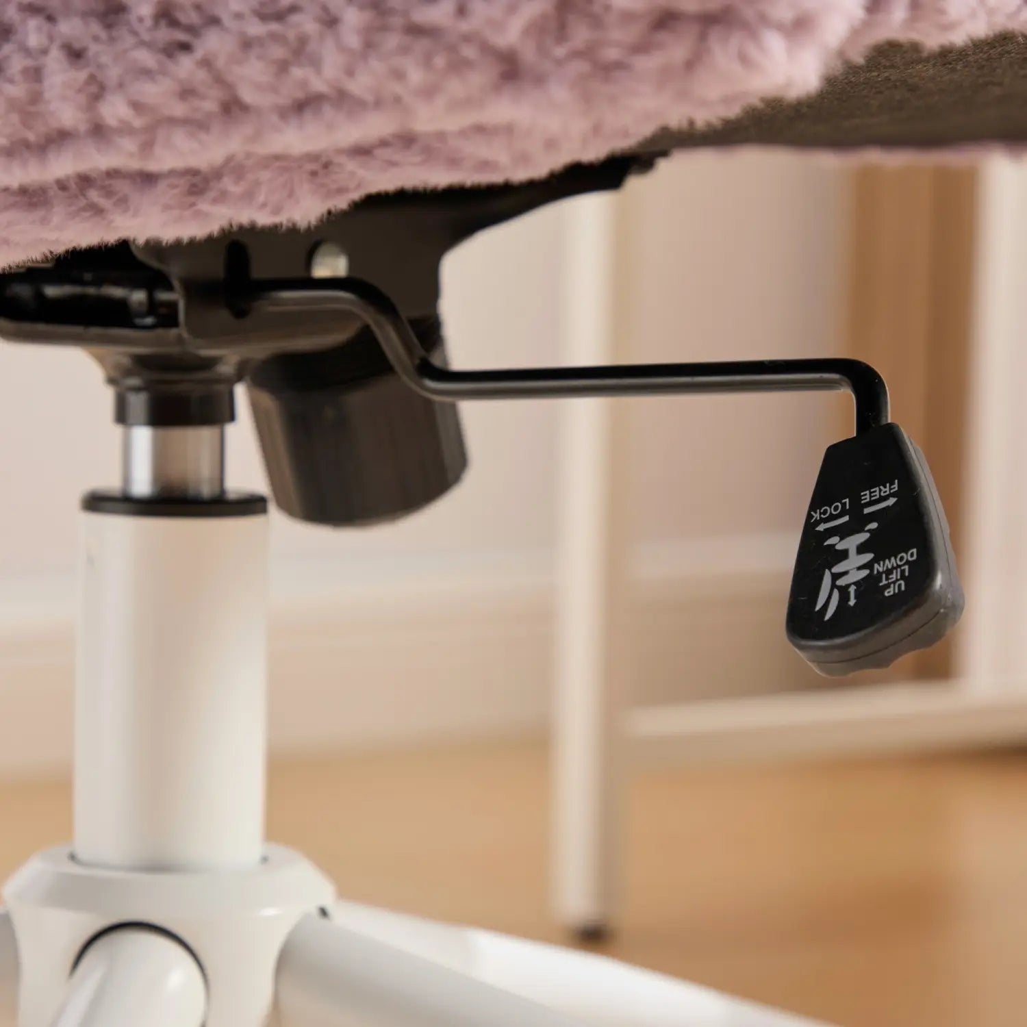Levier de réglage de la hauteur en plastique noir, avec des indications haut et bas affichées sur la face arrière du fauteuil de bureau en fausse fourrure violette avec une assise de 26,4 pouces de largeur