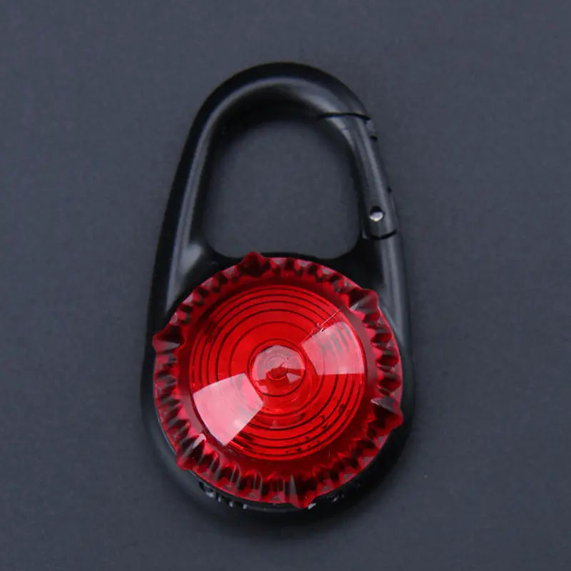 Pince de sécurité pour collier de chien à DEL, comportant un corps de type mousqueton en carabine noir avec une lentille circulaire rouge éclatante, des stries concentriques et une finition brillante.