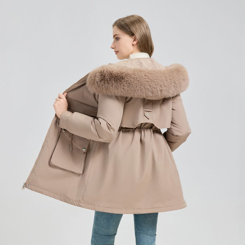 Beiger winterlicher Parka mit Fellfutter mit kuscheligem hellbraunem Fellfutter an der Kapuze und Fronttaschen.