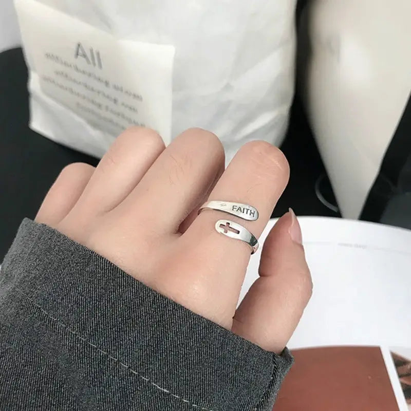 Silver faith cross wrap ring with adjustable band featuring a minimalist design and cross emblem.