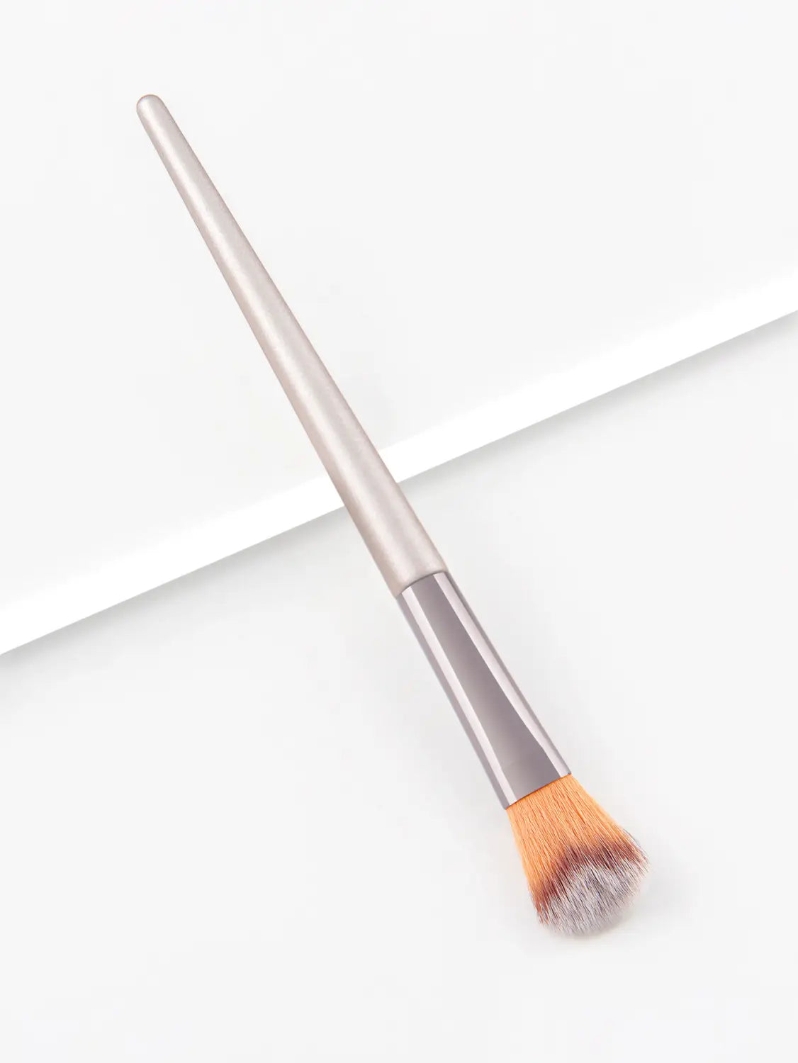 A sleek silver finger belly makeup brush professional contour tool with a tapered handle and soft gradient bristles transitioning from orange to gray.