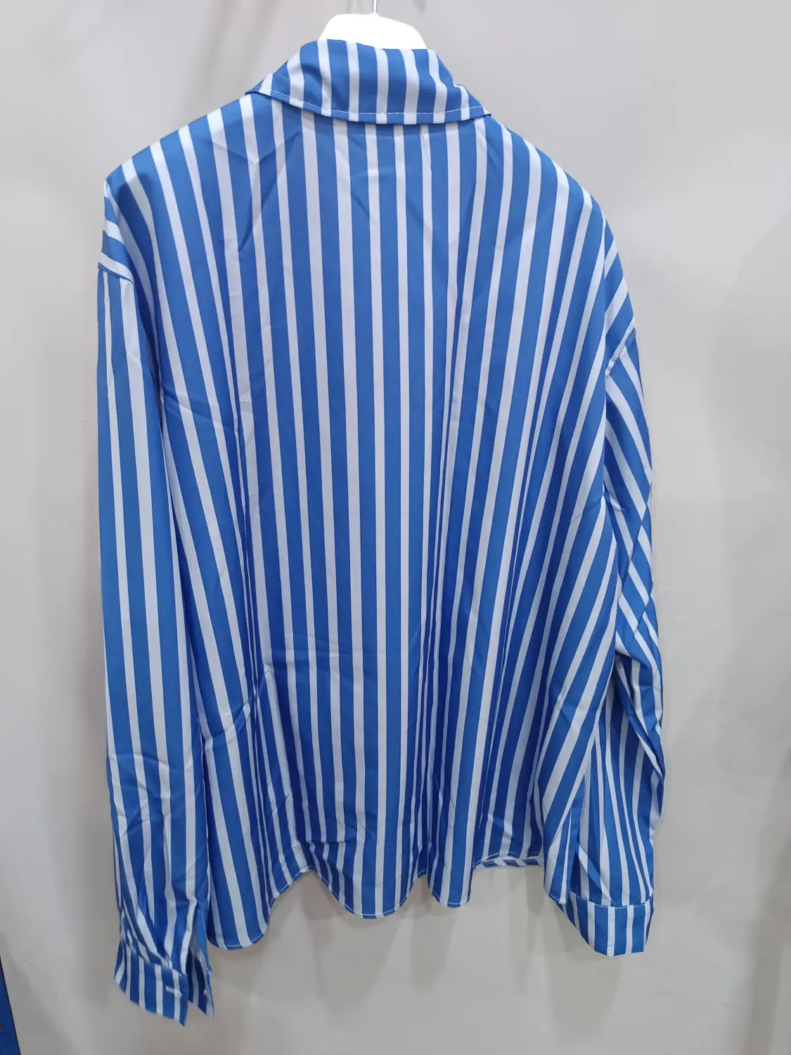 Chemise décontractée à manches longues rayée verticalement bleu et blanc pour hommes, avec col classique et patte boutonnée.