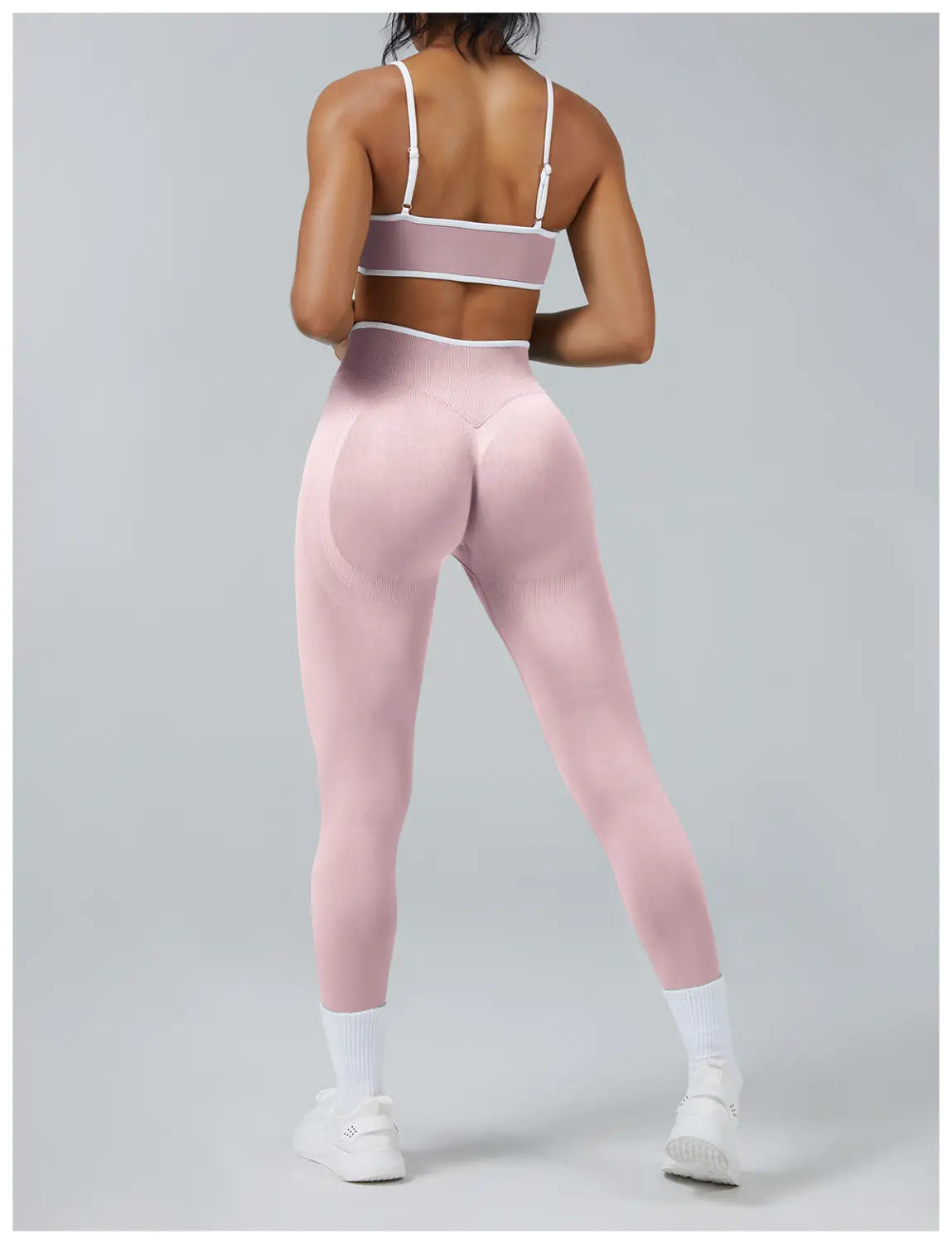 Seamless high waist sports yoga leggings in pink with white trim and mesh detailing on the matching bra top designed for activewear.