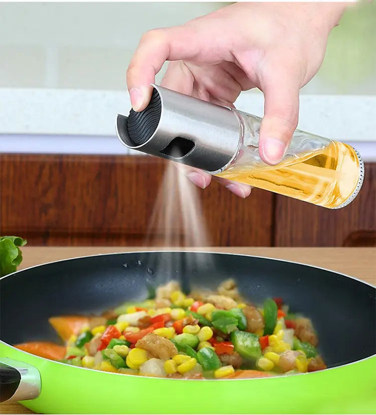 Ölsprühflasche zum Kochen aus klarem Glas und Edelstahl mit einem schwarzen, strukturierten auslaufsicheren Deckel.