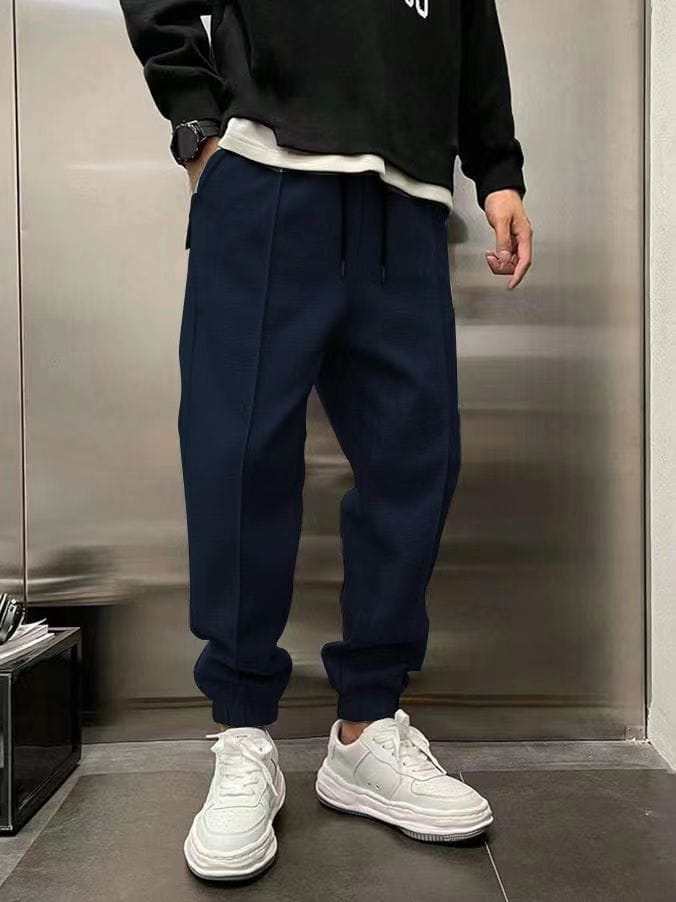 Men’s fleece drawstring sweatpants in navy blue with tapered legs, drawstring waist, and ribbed cuffs.
