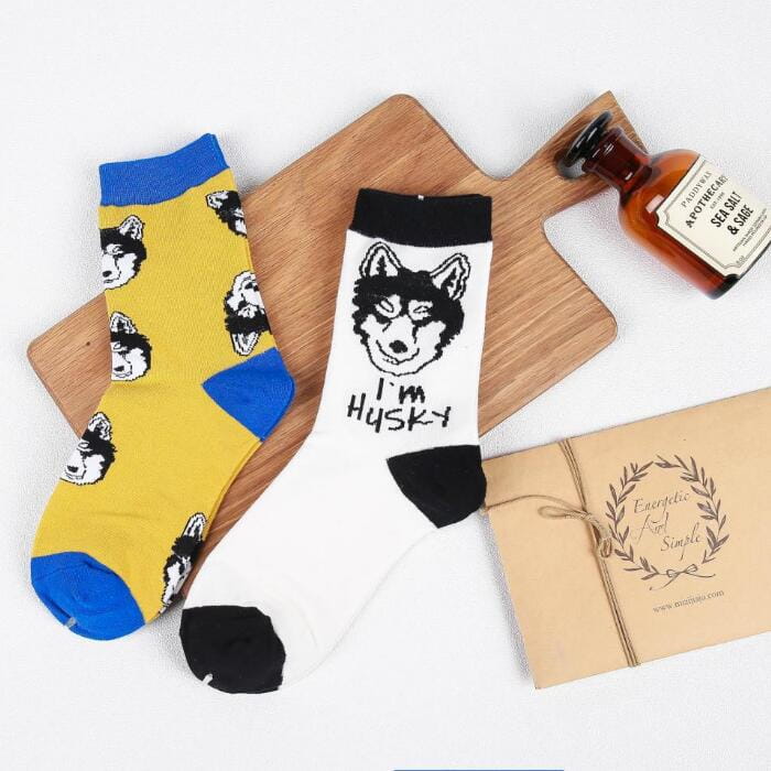 cute dog cartoon cotton crew socks featuring yellow and blue husky-themed designs with black paw prints paired with a white sock displaying a black im husky motif.