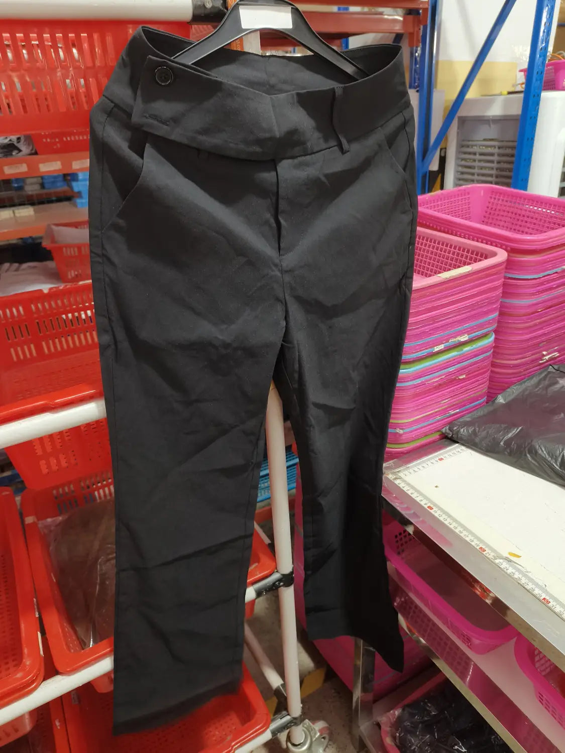 Black high-waisted wide leg work pants with a sleek tailored design and button closure suitable for casual wear.