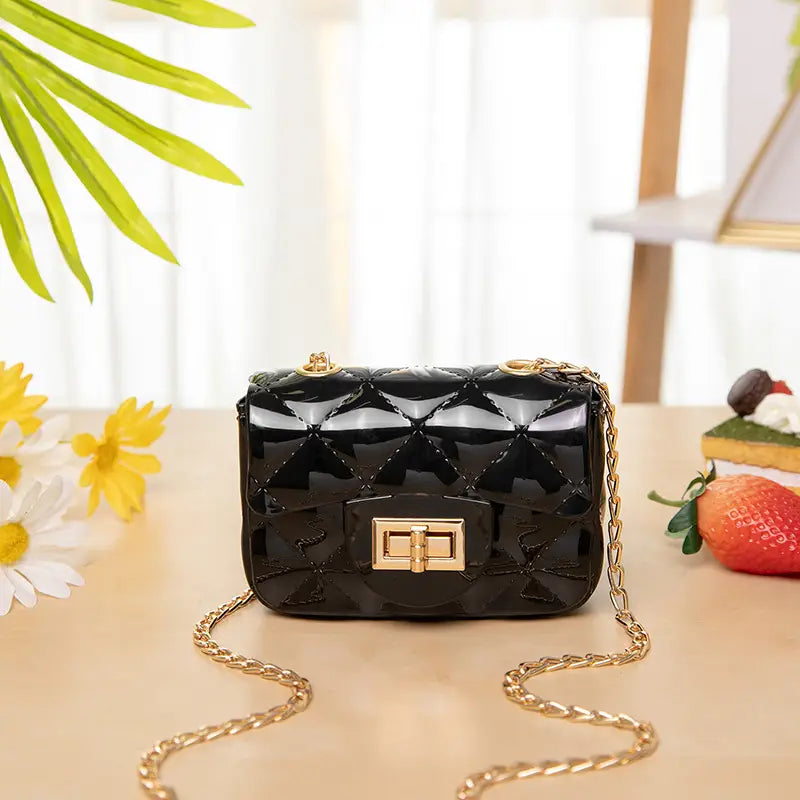 Black quilted patent leather mini crossbody bag for women with gold-tone chain strap and clasp.