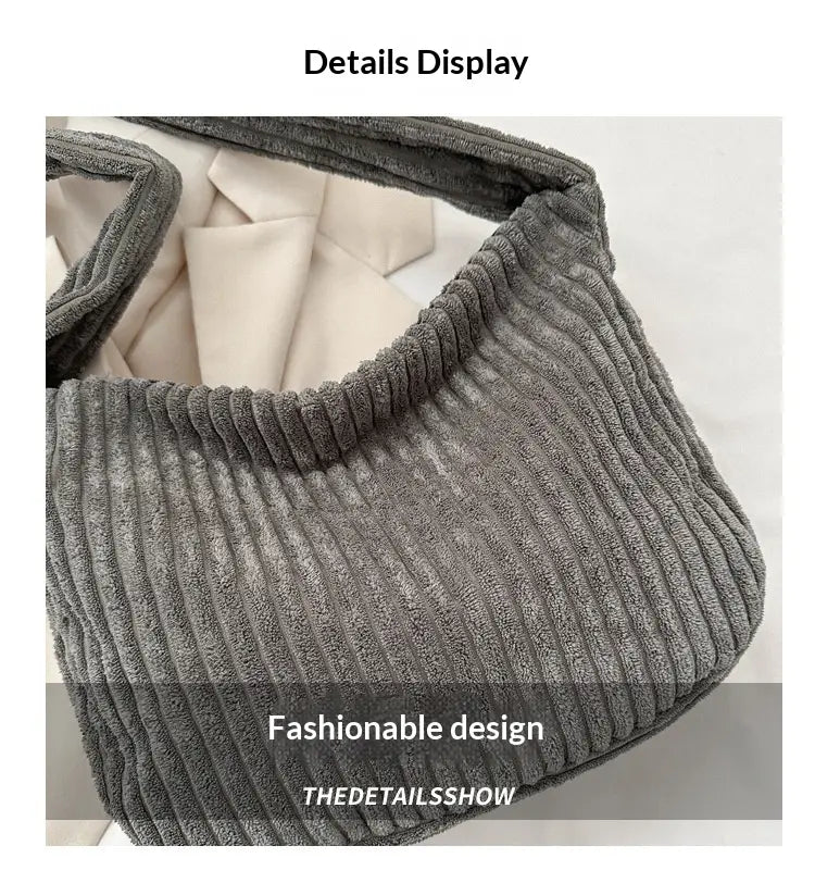 Schwarzer Corduroy-Schulterbeutel in Grau mit gerippter Textur und weichem, plüschigem Innenfutter, ausgelegt für die Nutzung in minimalistischer Streetwear.