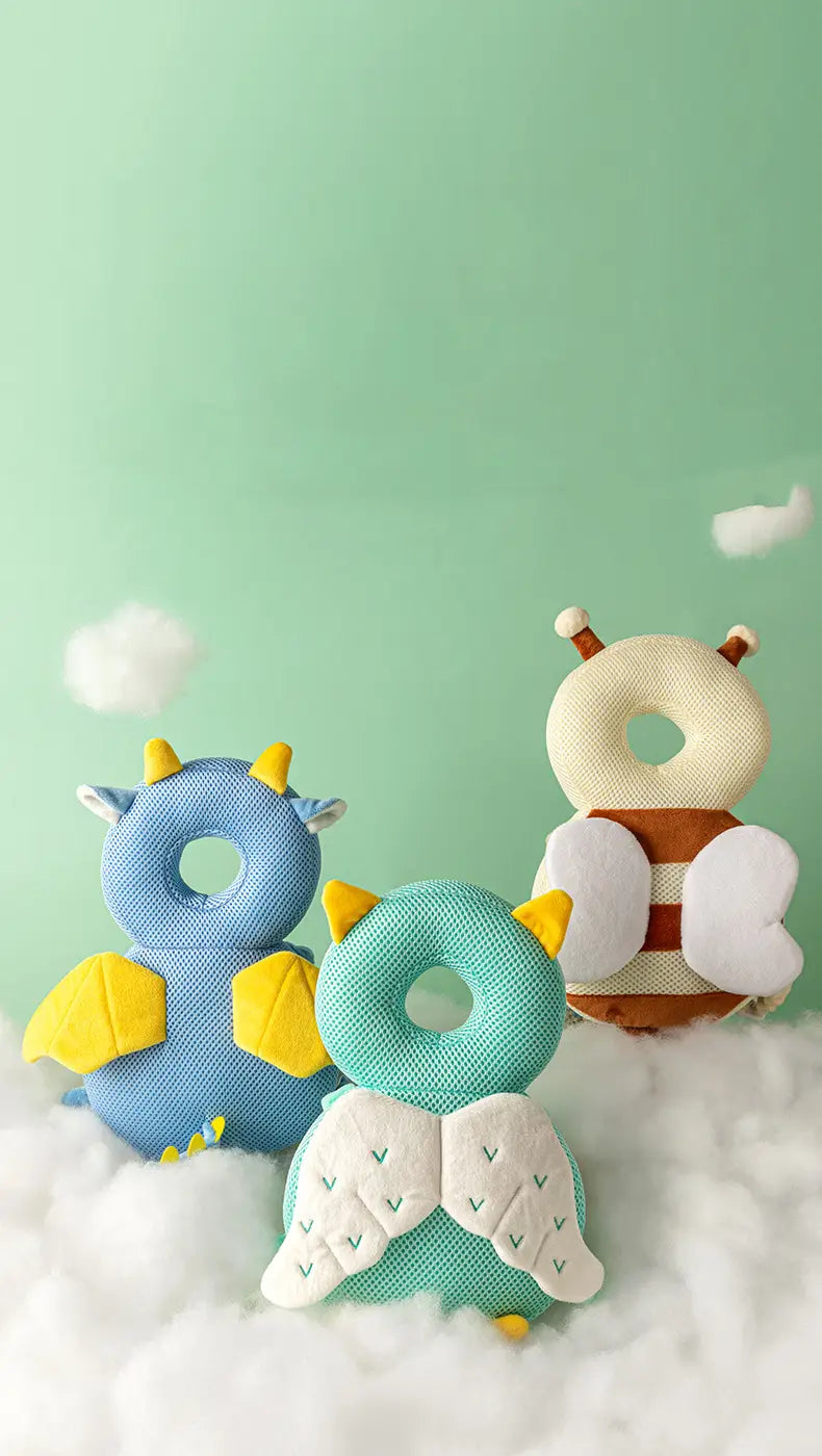 three plush donut-shaped baby head protector anti fall backpack cushions with wings and horns in soft pastel blue teal and beige colors