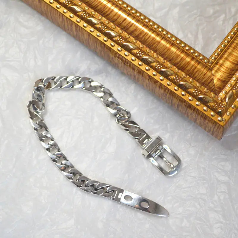 Women’s platinum plated stainless steel buckle chain bracelet in silver tone with polished curb links and a buckle clasp.