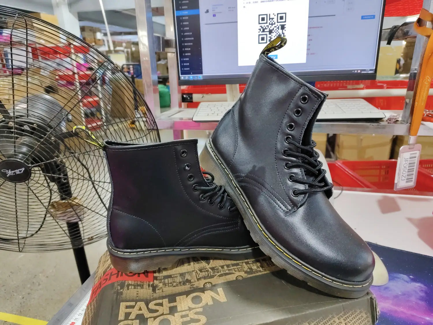 Black leather dr standing in front of burgundy leather martin boots with yellow stitching.