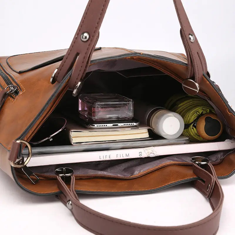 Retro large capacity leather tote crossbody bag in brown leather featuring multiple compartments and silver toned hardware.