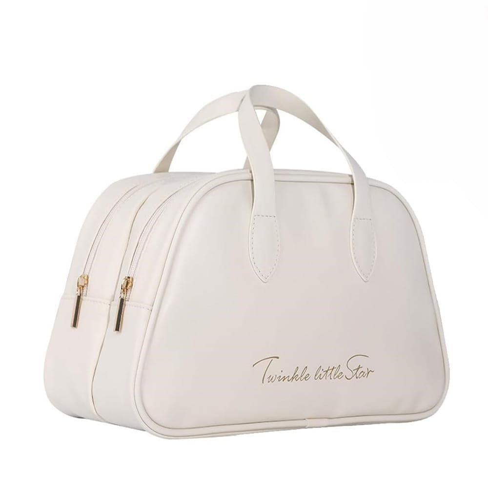 Une trousse de maquillage de voyage en cuir souple de couleur crème à l’aspect cuir, avec des fermetures éclair et des anses de tonalité dorée, issue d’un ensemble de trousses de toilette en cuir imperméable.