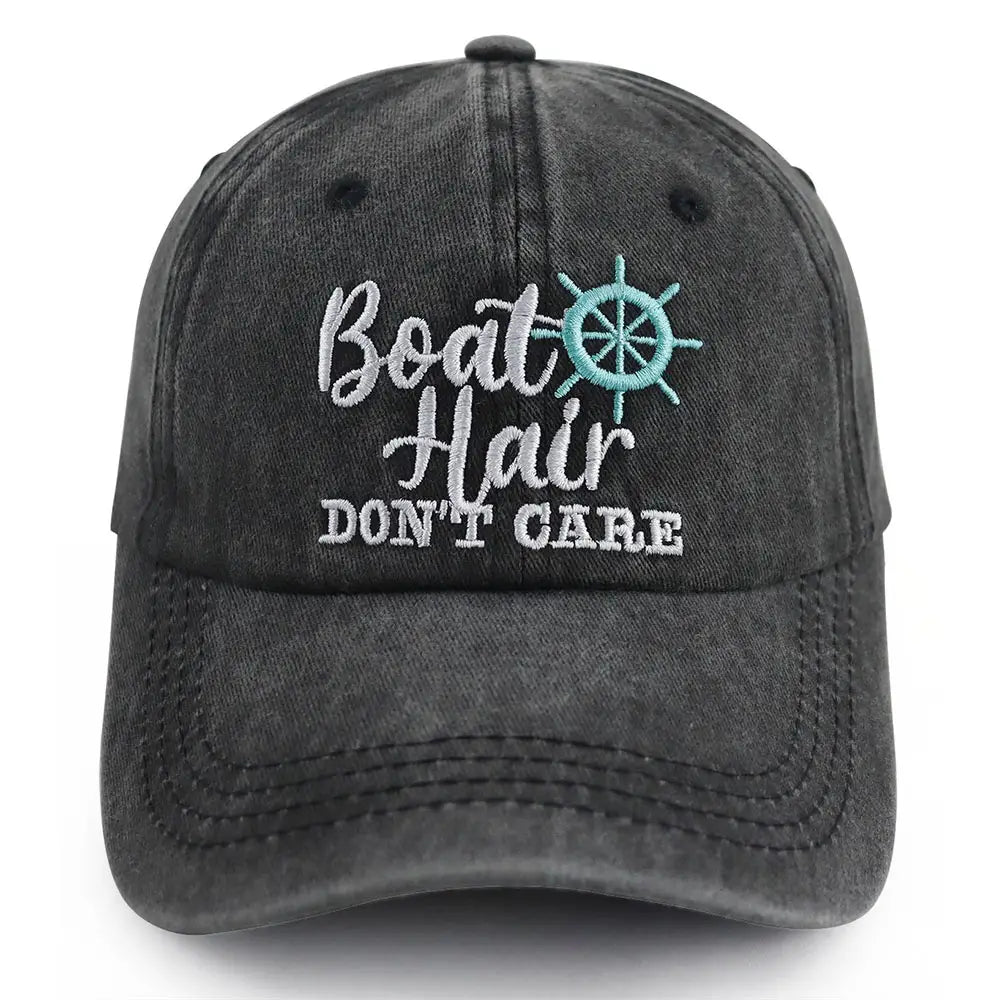 A dark gray distressed denim baseball cap featuring embroidered white script and a teal ship’s wheel design titled Boat Hair Don’t Care embroidered baseball cap.