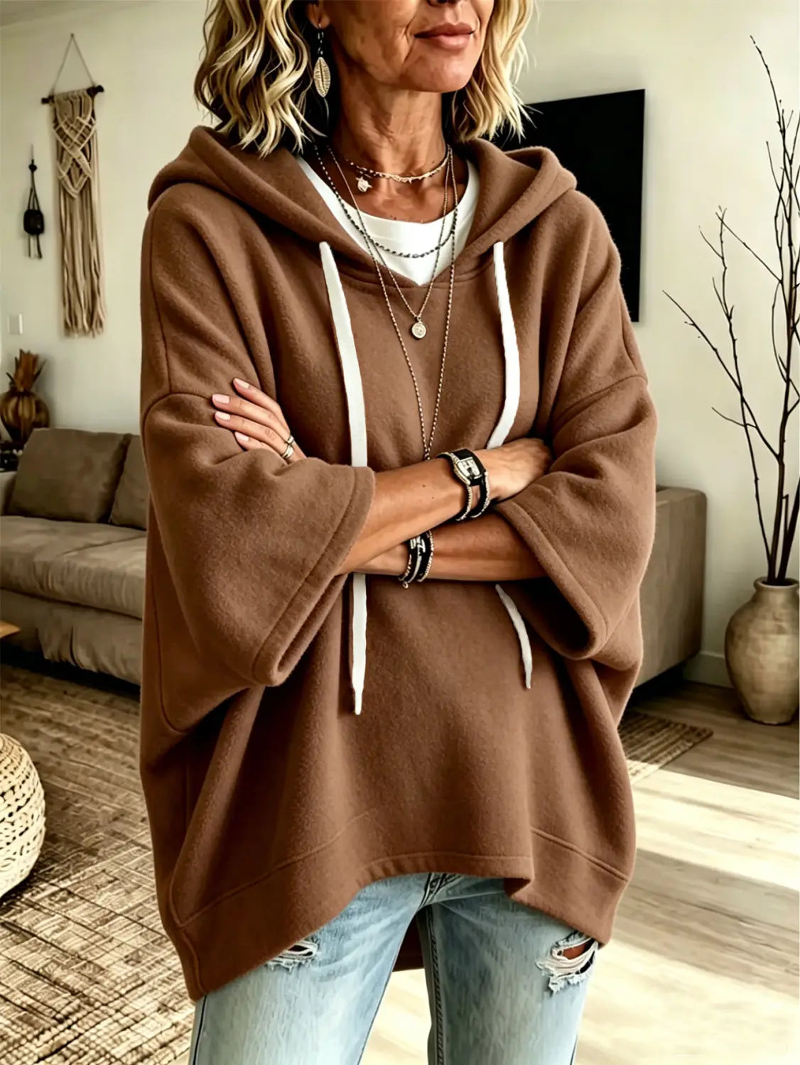 A cozy brown oversized fleece hooded top with white drawstrings and three-quarter sleeves featuring a relaxed slouchy fit.