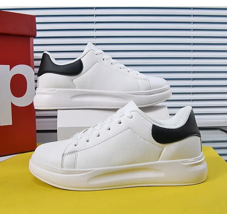 Baskets de loisirs épaisses et imperméables en cuir blanc, au design bas blanc et noir, avec un dessus en cuir lisse et une semelle blanche massive.