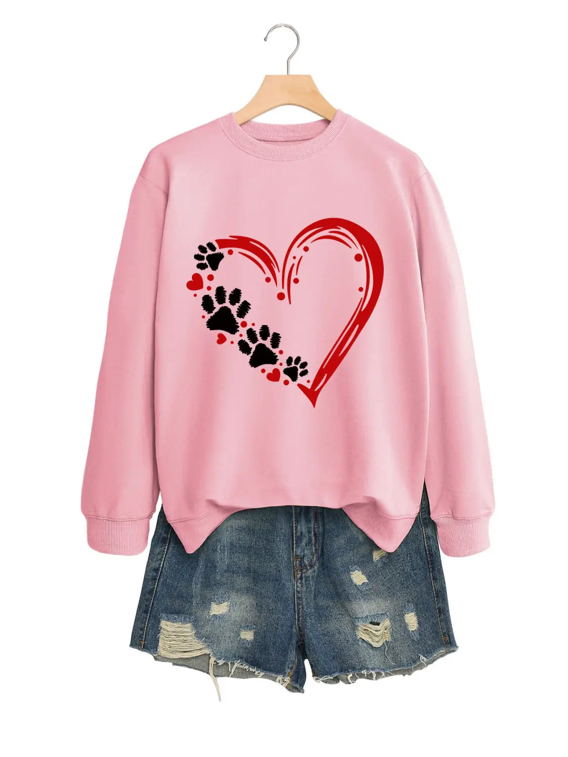 Sudadera rosa de manga larga con diseño de un corazón rojo, huellas de pata negras y pequeños corazones rojos, conocida como la sudadera con capucha pulóver Heart Paw Print.
