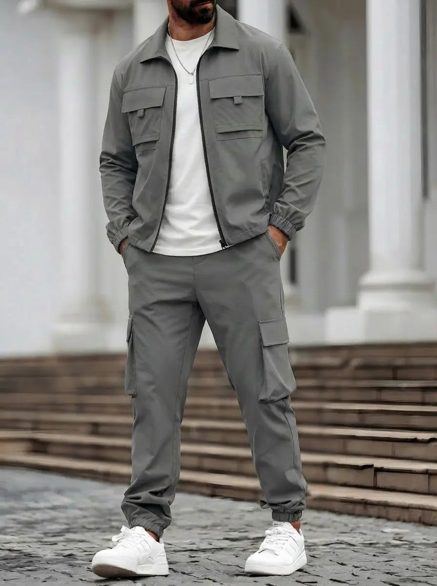 Men’s utility zip up workwear set featuring a gray utility jacket with two chest pockets and elastic cuffs paired with matching cargo pants.