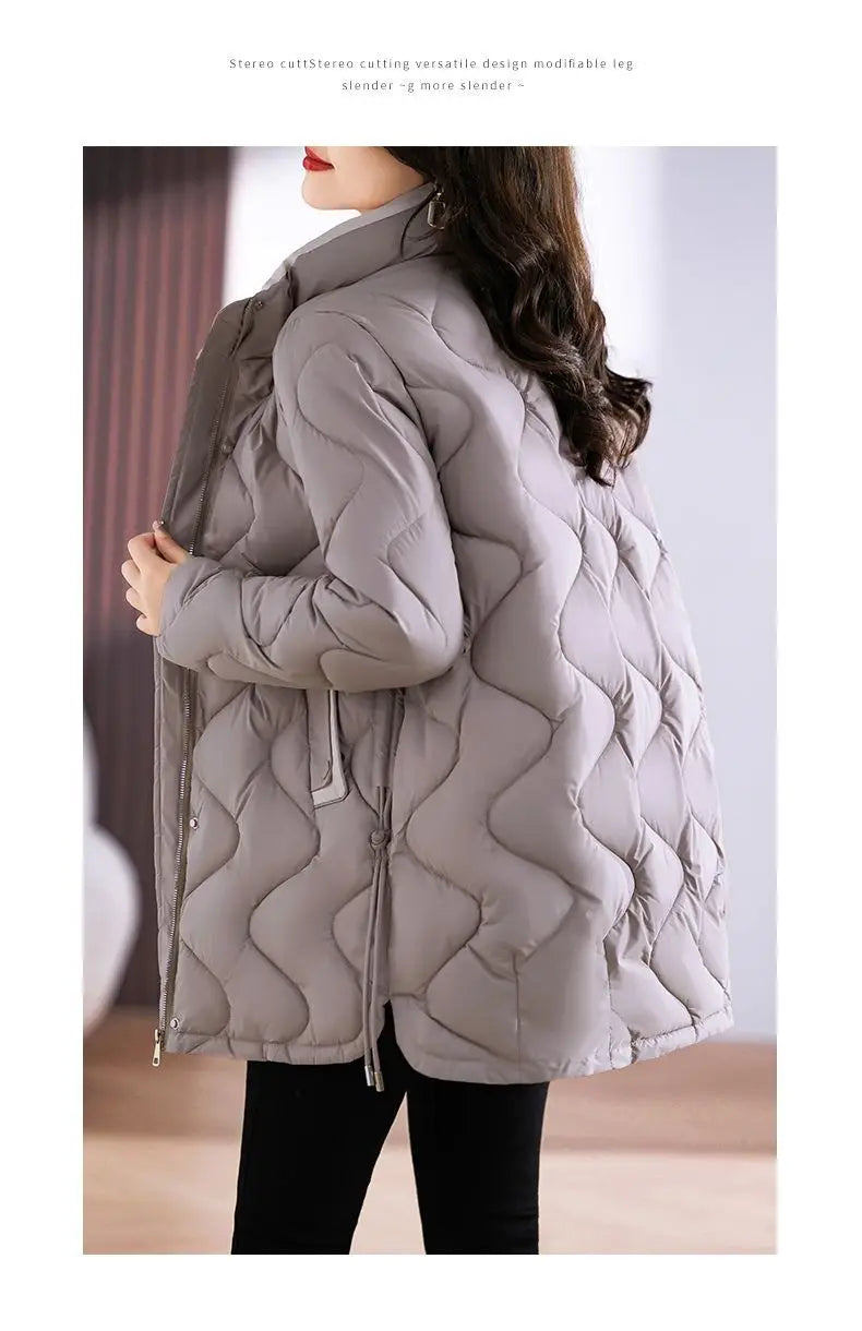 Chaqueta acolchada tipo puffer gris con cuello alto y cierre con cremallera, presentada en un producto titulado abrigo de invierno marrón acolchado de algodón con relleno.