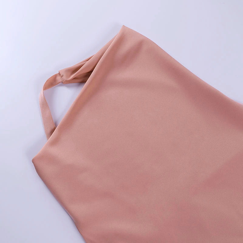 A soft peach-colored satin halter mini party dress featuring a smooth, slightly glossy finish and neatly stitched straps.