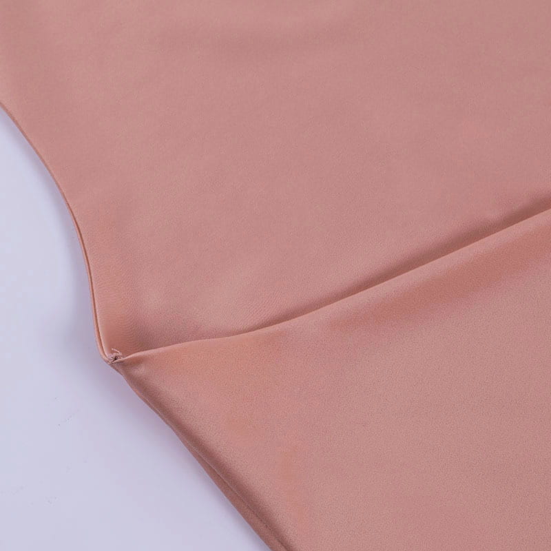 A soft peach-colored satin halter mini party dress with a smooth glossy finish and neatly stitched edges.