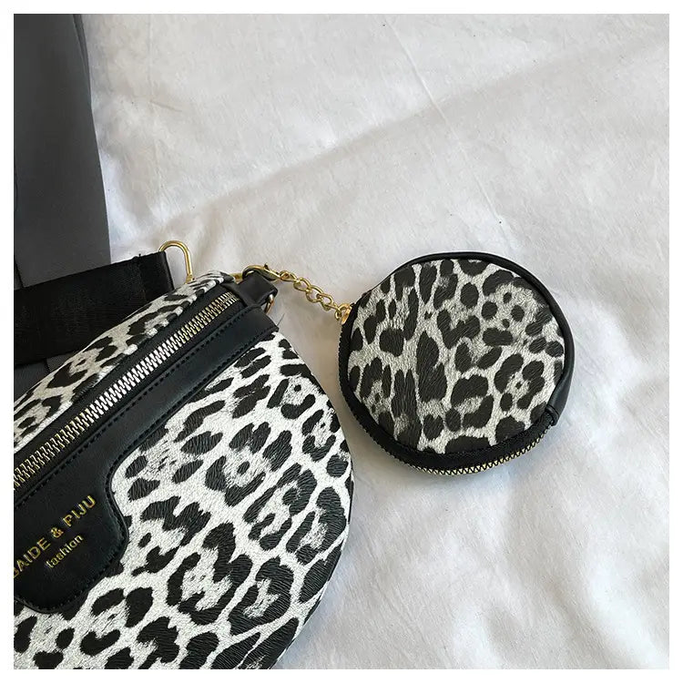 Sac bandoulière à imprimé léopard noir et blanc avec bordure en cuir et pochette à monnaie circulaire assortie, fixée par une chaîne en or.