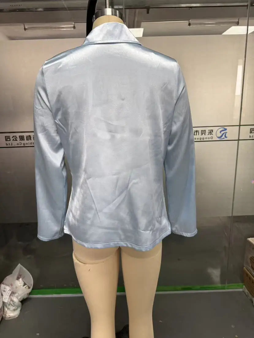 A light blue satin blazer with a sleek shiny finish and long sleeves for women’s elegant cowl neck satin long sleeve blouse.