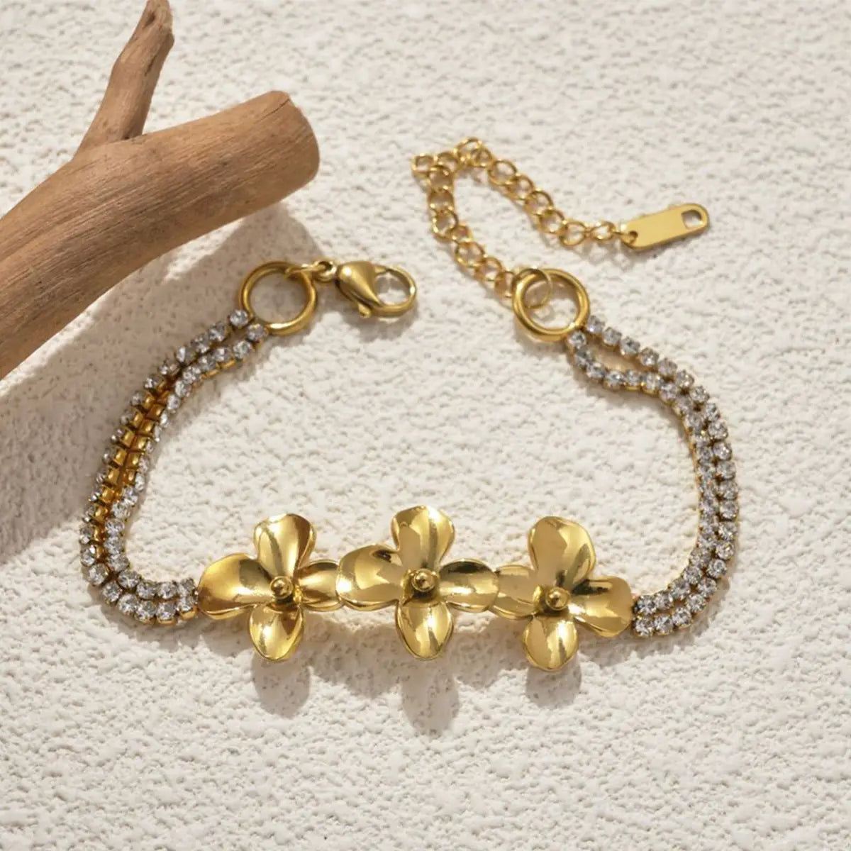 18k gold plated crystal flower double strand bracelet featuring a gold-toned chain with three prominent flower charms and two rows of sparkling rhinestones.