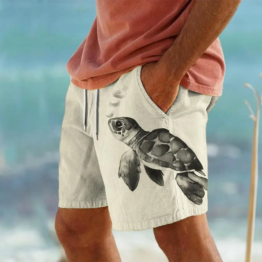 Beige men’s striped tropical print swim trunks featuring a detailed black and gray watercolor-style sea turtle graphic on the front.