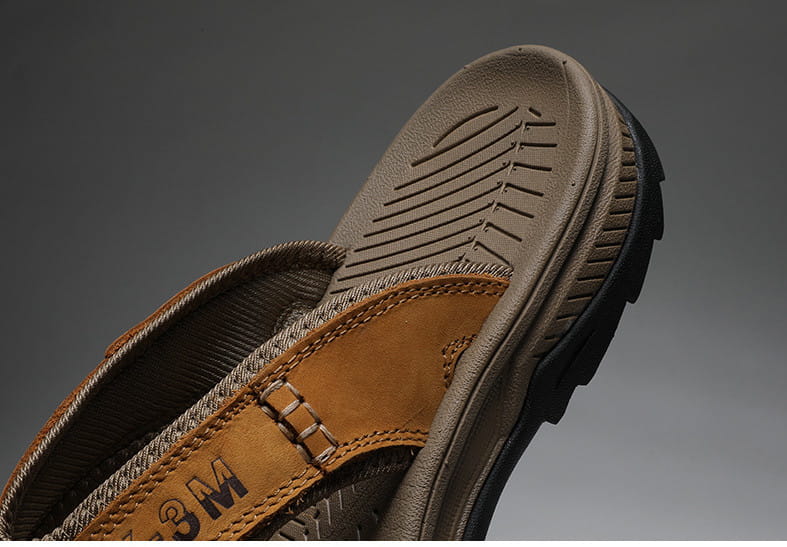 Tan leather men’s beach sandal with rugged textured sole and reinforced stitching designed for outdoor sport use.