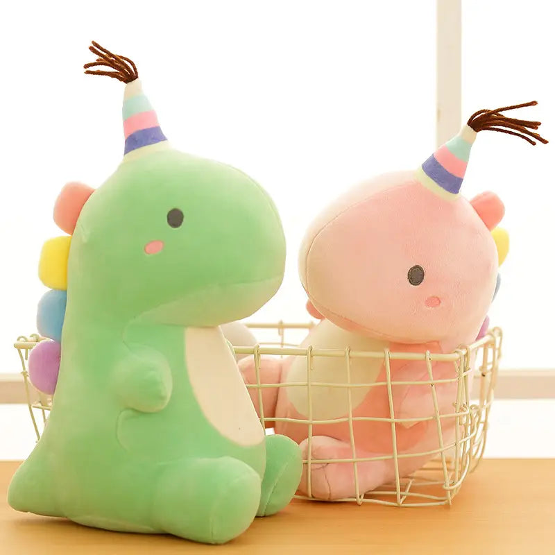 Niedliche grüne und pinkfarbene Dinosaurier-Plüschtierchen mit Regenbogen-Partyhüten sind weiche Kuscheltiere, die sich perfekt für Feiern eignen.
