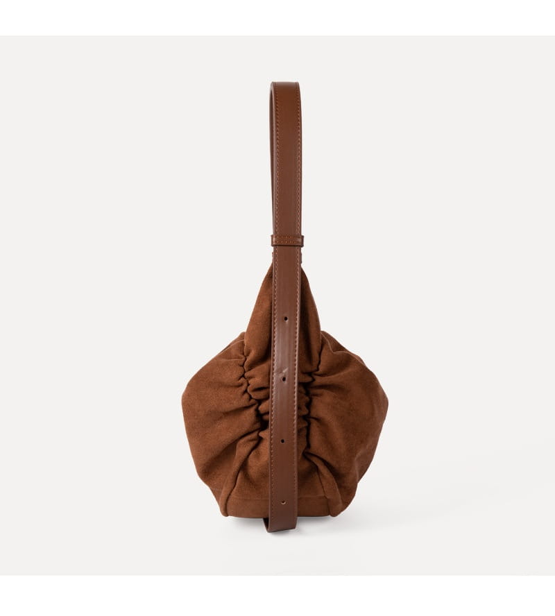 Brown suede ruched shoulder bag with a matching leather strap designed as a slouchy dumpling crossbody hobo bag.