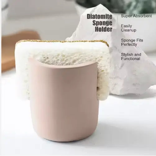 A matte pink cylindrical diatom mud sponge rack kitchen sink caddy holder with a white diatomite sponge nestled inside.