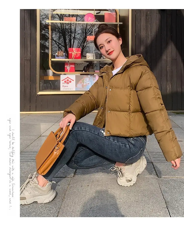 tan leather handbag with structured shape and top handle displayed alongside a women hooded short down jacket product.
