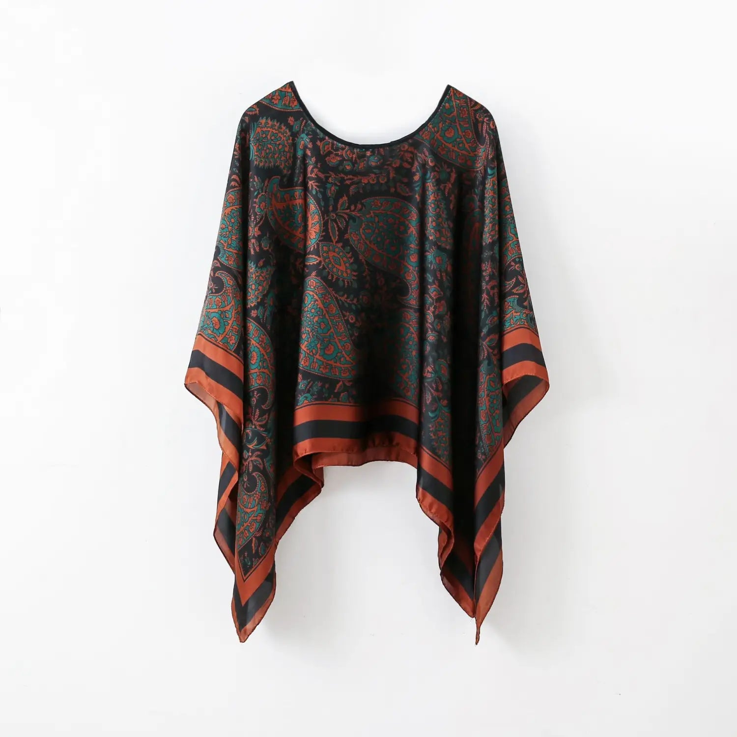 A flowing black green and rust-colored paisley-patterned silk poncho with a rounded neckline perfect as printed silk patterned pullover shawl cape outerwear.
