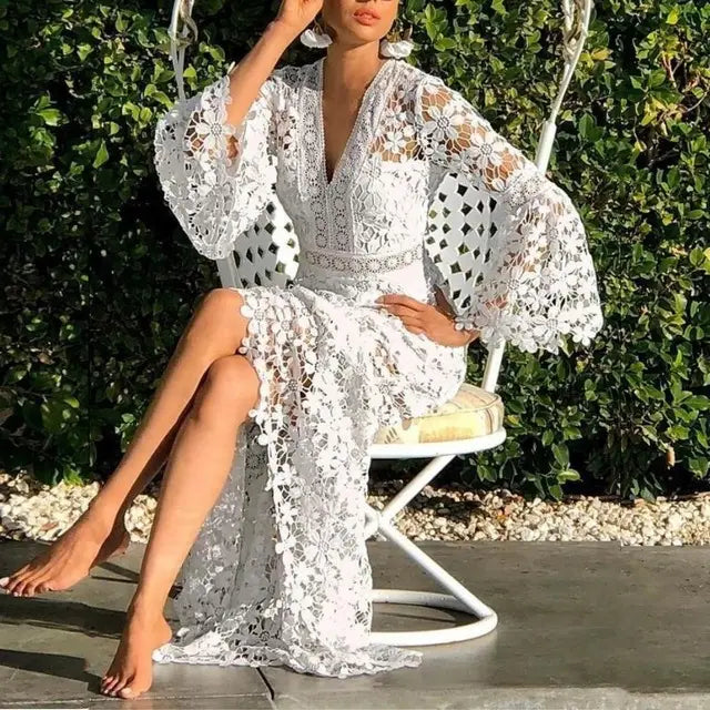 A white lace midi dress with intricate floral patterns and elegant bell sleeves.
