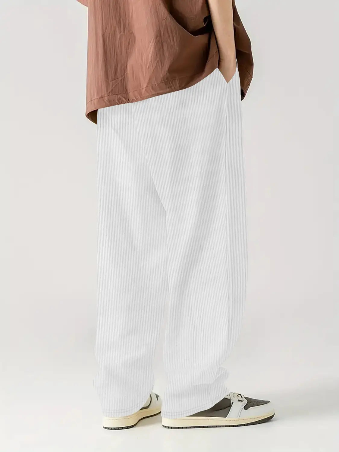 Pantalones casuales rectos de pana blancos con cordón, con rayas verticales sutiles.