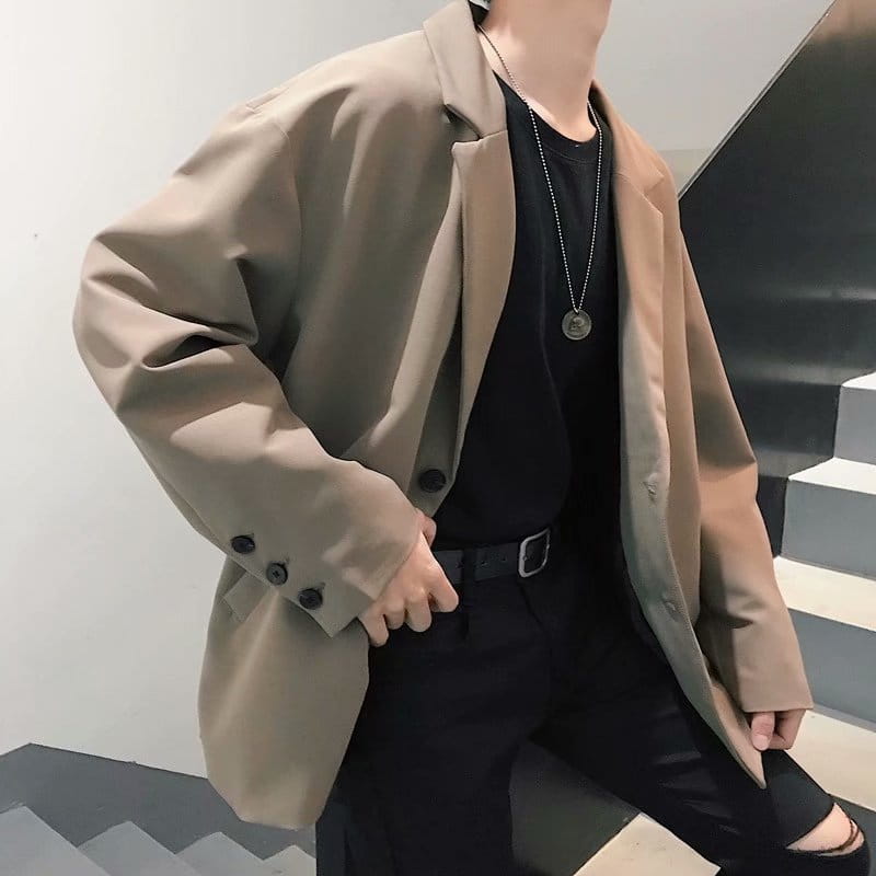 Beige oversized mens loose casual thin suit jacket with a relaxed fit and black buttons.