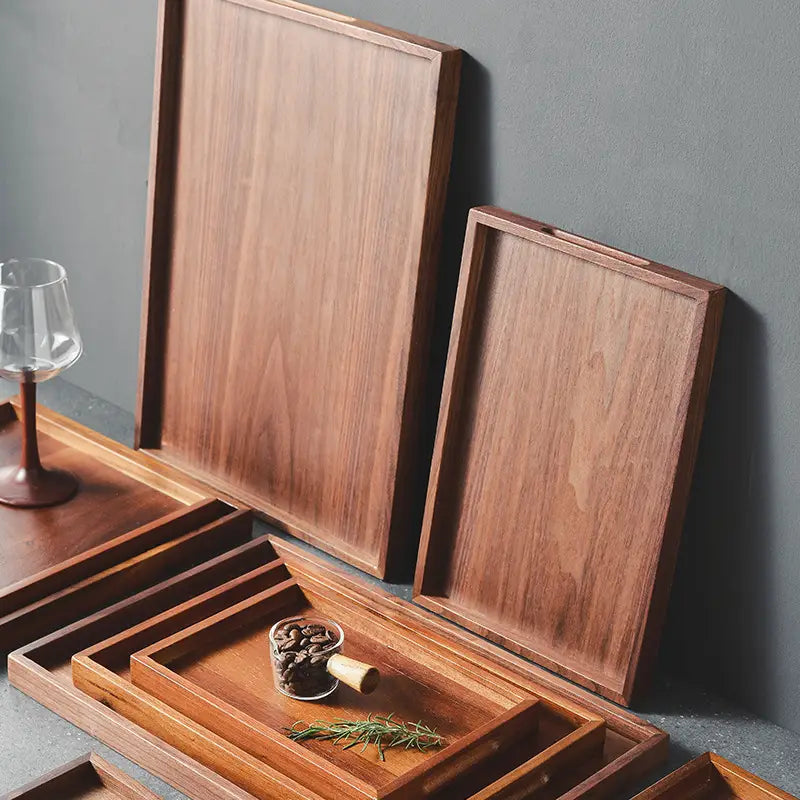 Set of acacia wood rectangular serving trays in rich warm brown tones with smooth polished surfaces and clean minimalist edges.