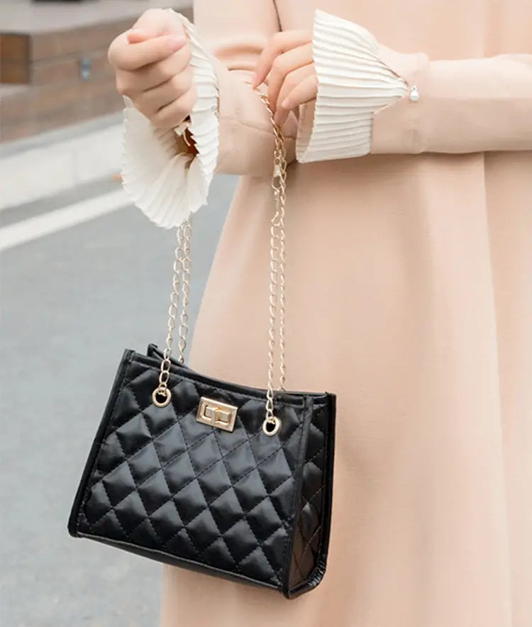 Black quilted mini chain shoulder bag with gold-tone chain strap and clasp in rhombus pattern small square design.