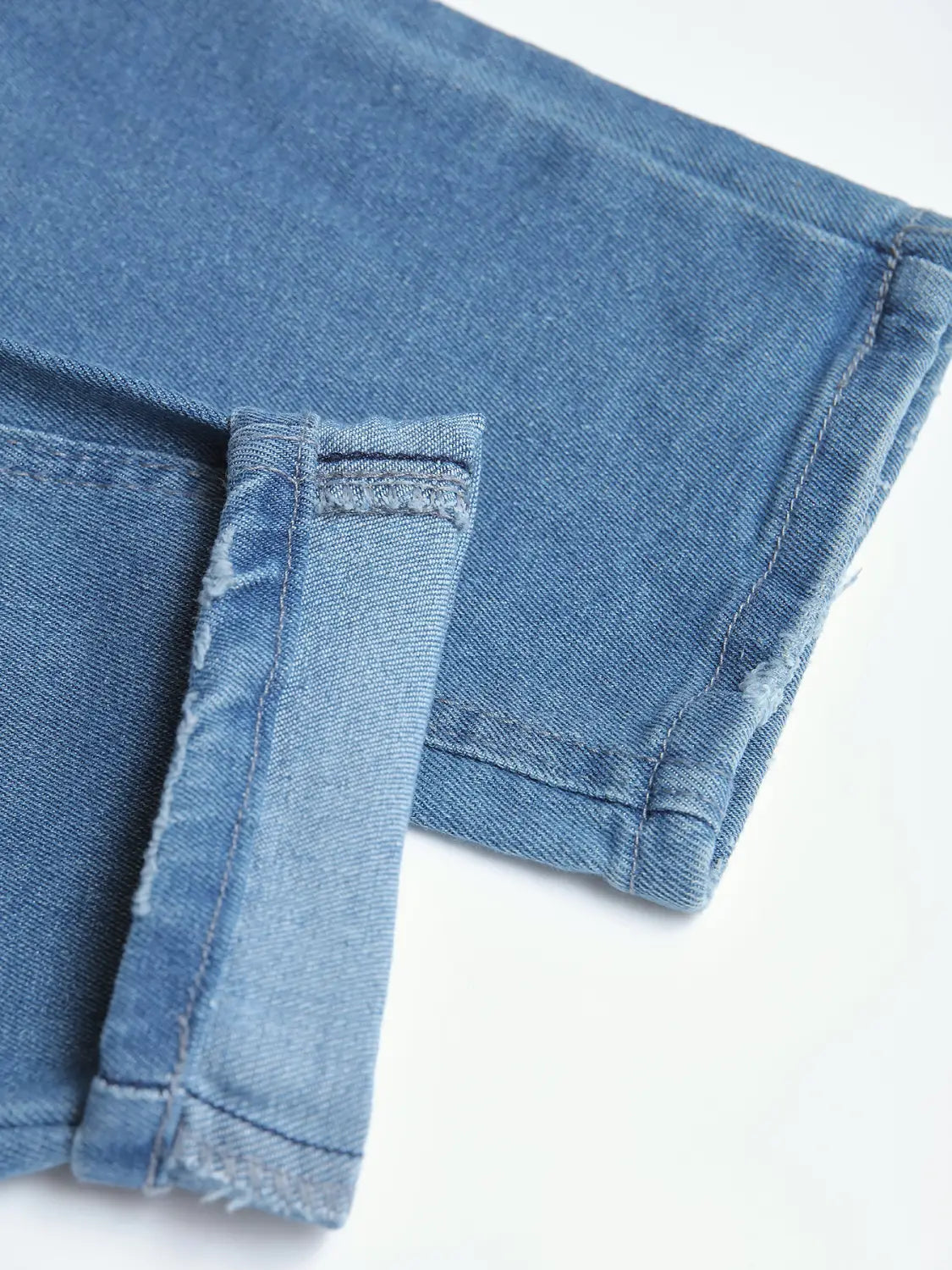 Men’s distressed slim fit stretch denim jeans in light-wash denim with a frayed hem and rolled cuff.