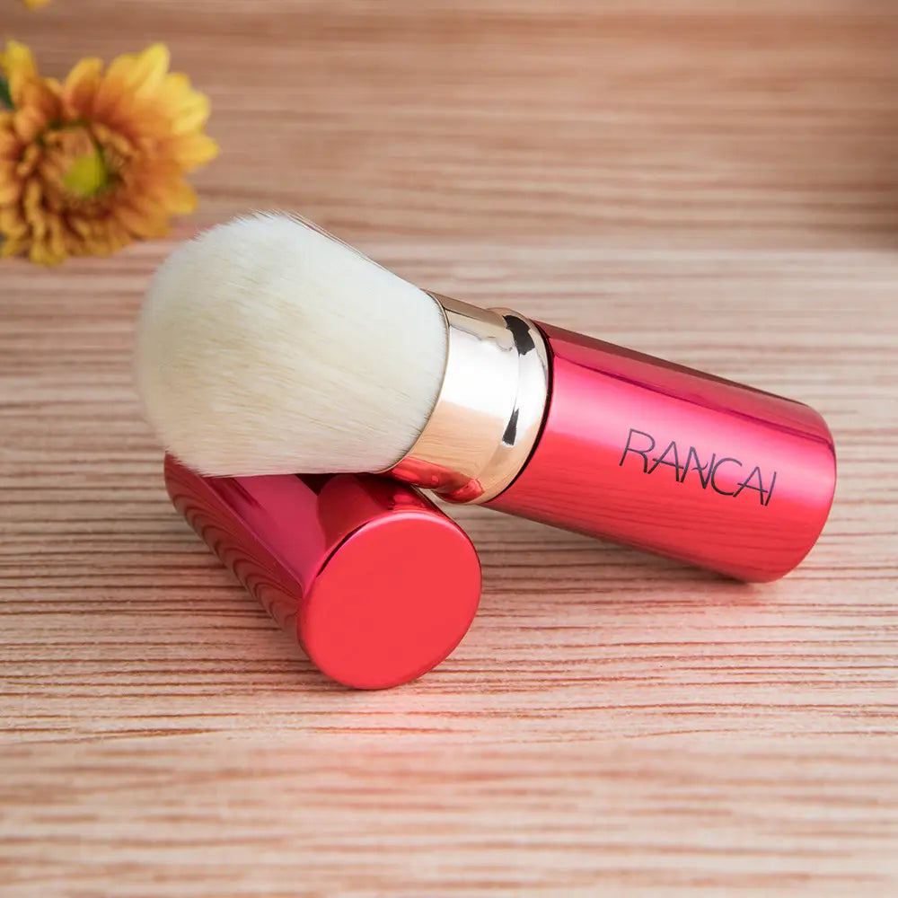 Retractable makeup brush mini red and gold rancai featuring a compact design with a white fluffy head and a metallic gold ferrule.