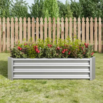 Lecho elevado de jardín de metal corrugado plateado, maceta galvanizada de 4x2x1 pies, con plantas con flores rojas en su interior.