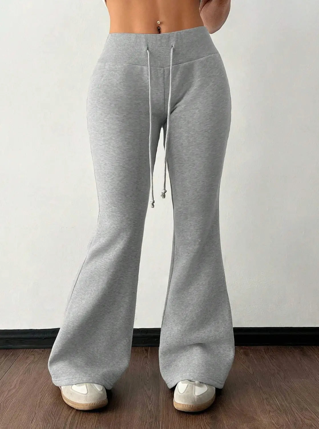 Gray heathered fleece lined high waist sweatpants with a drawstring and relaxed fit flaring at the ankles.