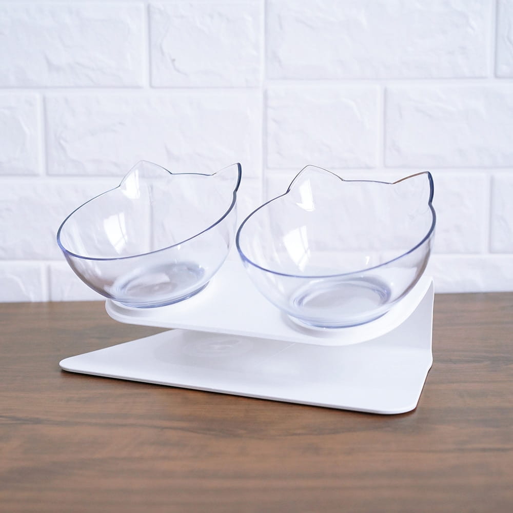 clear cat-shaped elevated pet bowls made of transparent material on a white stand with a 15 degree tilt double feeder design
