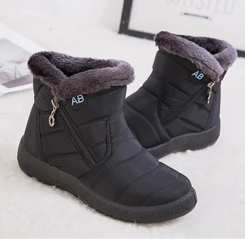 Bottes d’hiver imperméables noires avec un design matelassé, une doublure intérieure moelleuse en fausse fourrure grise, une fermeture éclair latérale et le logo de marque « ab » sur la cheville.