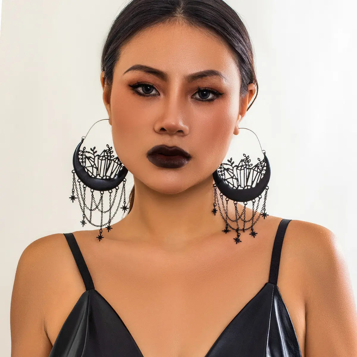 Ohrringe mit schwarzem Halbmond-Tassel-Design in Schwarz mit aufwendigen, spitzenartig wirkenden Details und baumelnden Sternketten.